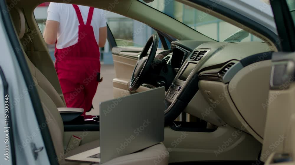 Mechanic gets out of repaired car with tablet in hands after testing