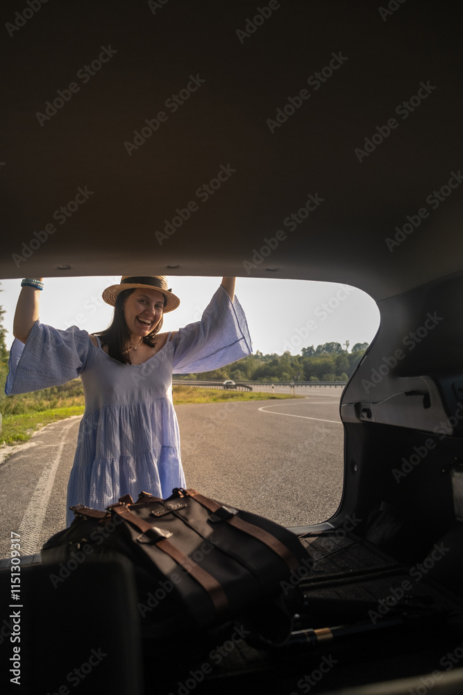 Fototapeta premium Smiling Woman with Backpack by Car on Scenic Road