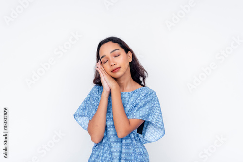 Young woman making a sleeping gesture in a medical gown photo