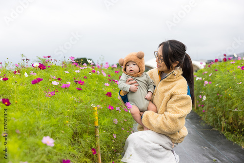 Woman with baby surrounded by blooming flowers photo