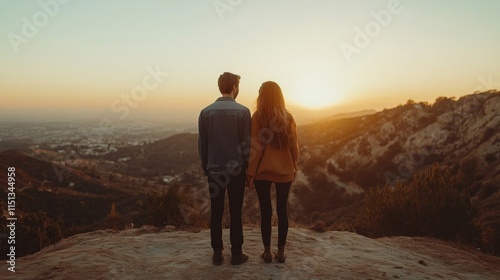 Couple Watching Sunset Over Cityscape From Mountaintop photo