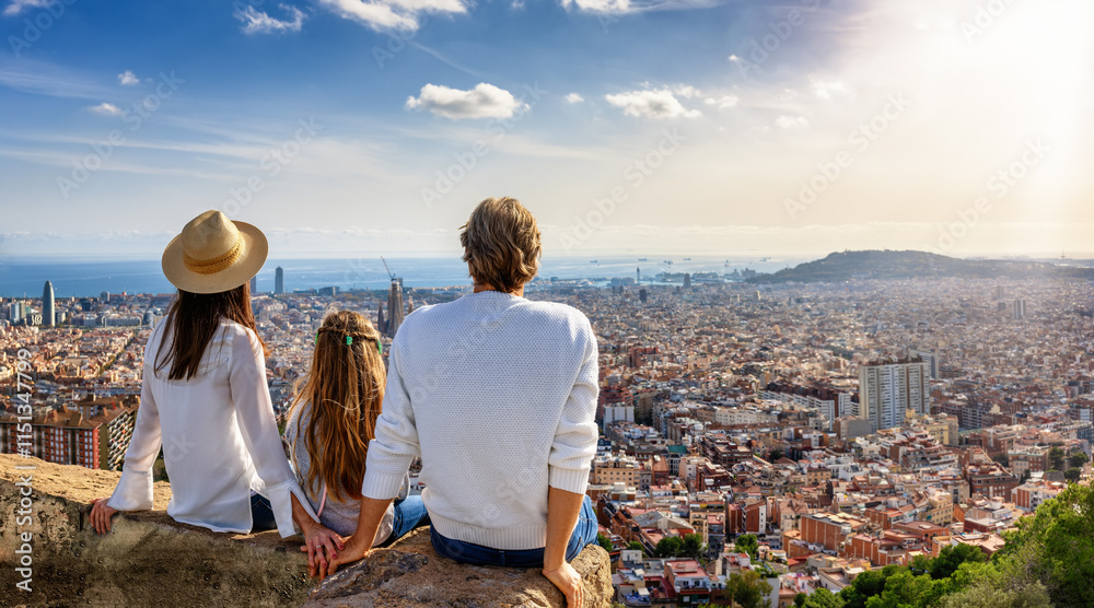 A tourist family enjoys the panoramic view of the skyline of Barcelona, Spain, during their city trip vacation