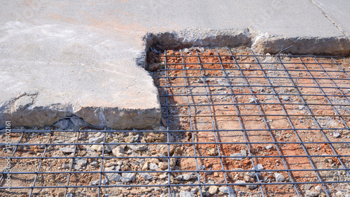 Reconstruction damaged broken street by reinforcing with reinforced steel deformed bar in a hole on concrete road surface photo