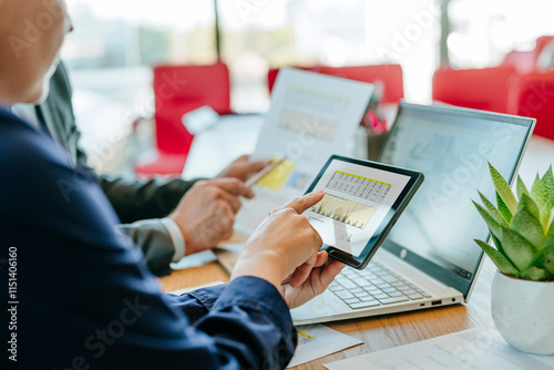 Business colleagues analyzing data on laptop and digital PC in office