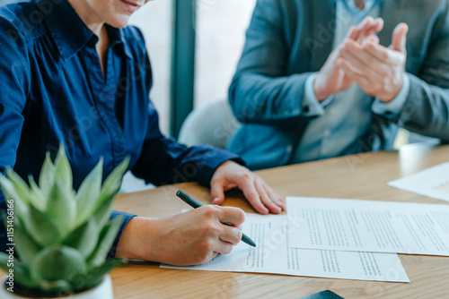 Businesswoman signing documents with colleague in office