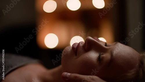 Soothing head massage unfolds in a dimly lit room, where calming candlelight creates a tranquil ambiance, promoting relaxation and wellness for the recipient