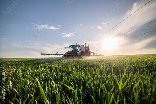 Tractor spraying wheat in field
