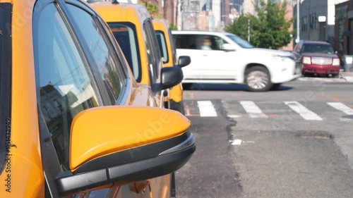 New York City. Row of yellow Taxi cars on street, Queens. Many taxi cabs on avenue, Long Island, LIC. Medallion taxicab and Manhattan Midtown urban skyline cityscape. High-rise building architecture.
