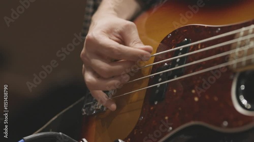 A musician playing their orange and red electric guitar with a guitar pick during a live combo performance