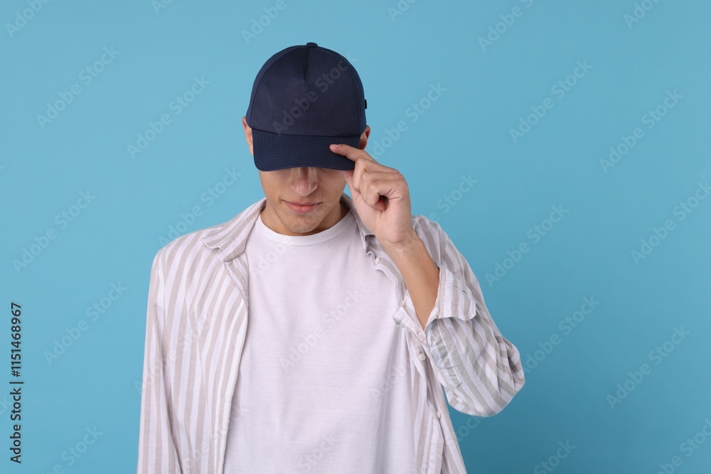 Man in stylish baseball cap on light blue background. Mockup for design Man in stylish baseball cap on light blue background. Mockup for design