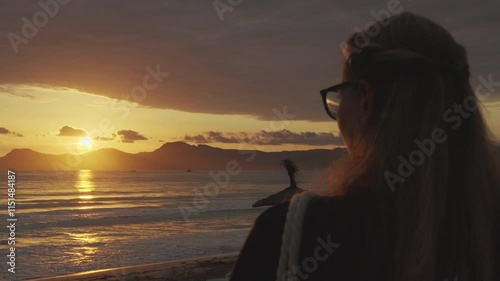 A woman enjoys the view of the sea at sunrise photo