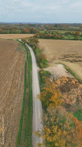 Vertical aerial footage of a road passing the fields in the countryside of Tonbridge, England photo