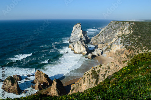 Sand beach among rocks. Ursa Beach near Cape Roca (Cabo da Roca) at Atlantic Ocean coast in Portugal. Majestic coastal cliffs with turquoise waves and sandy beaches photo