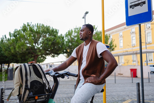 Young man waiting for bus while sitting on bicycle at bus stop in lisbon