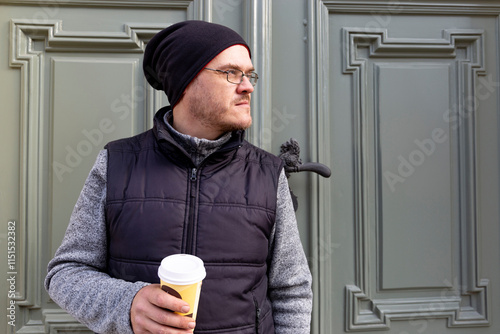 Obraz na płótnie A man with a cup of coffee walking through an autumn city. w salonie