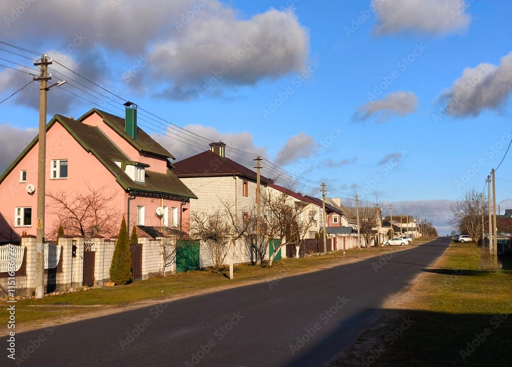 Naklejka premium Real estate concept: City street of single-family modern houses against blue sky. A number of private houses in a residential area in Europe.