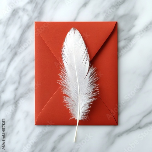 A white feather on a red envelope. Creative flat lay on light marble background.
