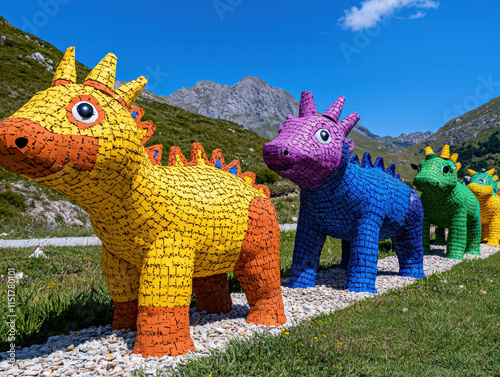 Recycle conservation renewal sustainability concept. Colorful, whimsical dinosaur sculptures displayed outdoors in a scenic landscape. photo