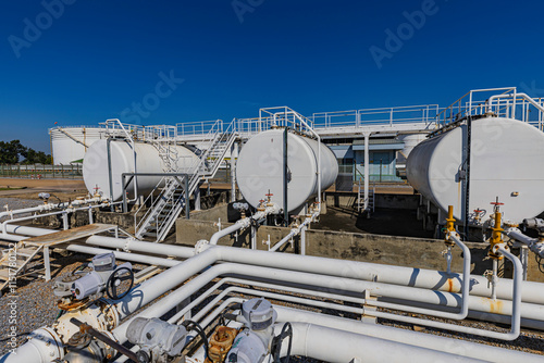 Horizontal tank oil white Storage Fuel Gas Container Tanks in Petroleum Refinery Industrial Factory area against Blue Sky