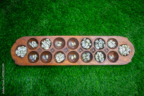 Congklak, Indonesian traditional board game from wood and sea shells as the seeds photo