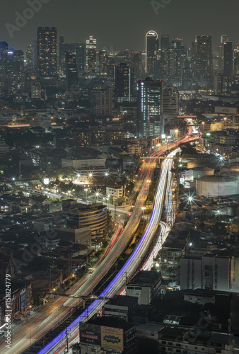 Night view of light trails of cars on the road of Bangkok city. Nightscape view of with bright glowing lights after sunset, Long exposure for Light curve lines, use it as your Wallpaper, Poster.