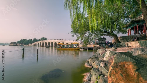 BEIJING, CHINA - OCTOBER 7, 2024: Tranquil lake view with ancient bridge at Summer Palace, showcasing cultural heritage