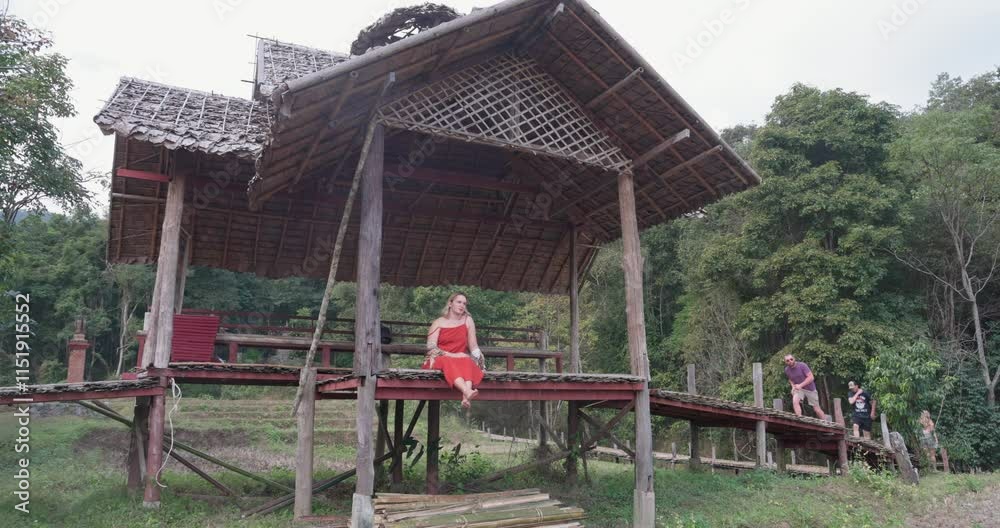 A young woman on a Kho Ku So Bamboo Bridge and rice fields in northern Thailand near Pai A young woman on a Kho Ku So Bamboo Bridge and rice fields in northern Thailand near Pai