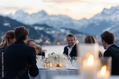 Guests enjoying a picturesque dinner party overlooking beautiful mountains, filled with laughter, conversation, and a warm, inviting atmosphere during twilight. photo