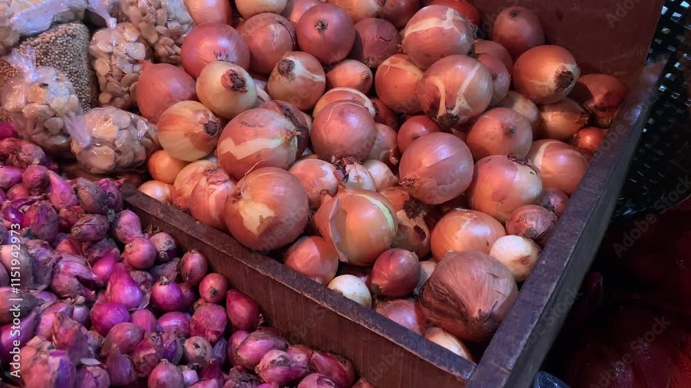 A mix of red and yellow onions in wooden crates at a traditional market. A mix of red and yellow onions in wooden crates at a traditional market.