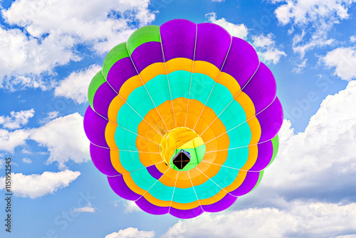 Colorful hot air balloon flying over blue sky with white clouds	 photo