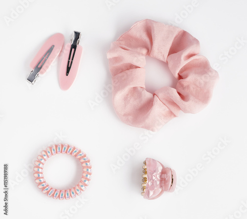 Collection of trendy pink silk elastic band scrunchies and hair clips on white background. Diy accessories and hairstyles concept