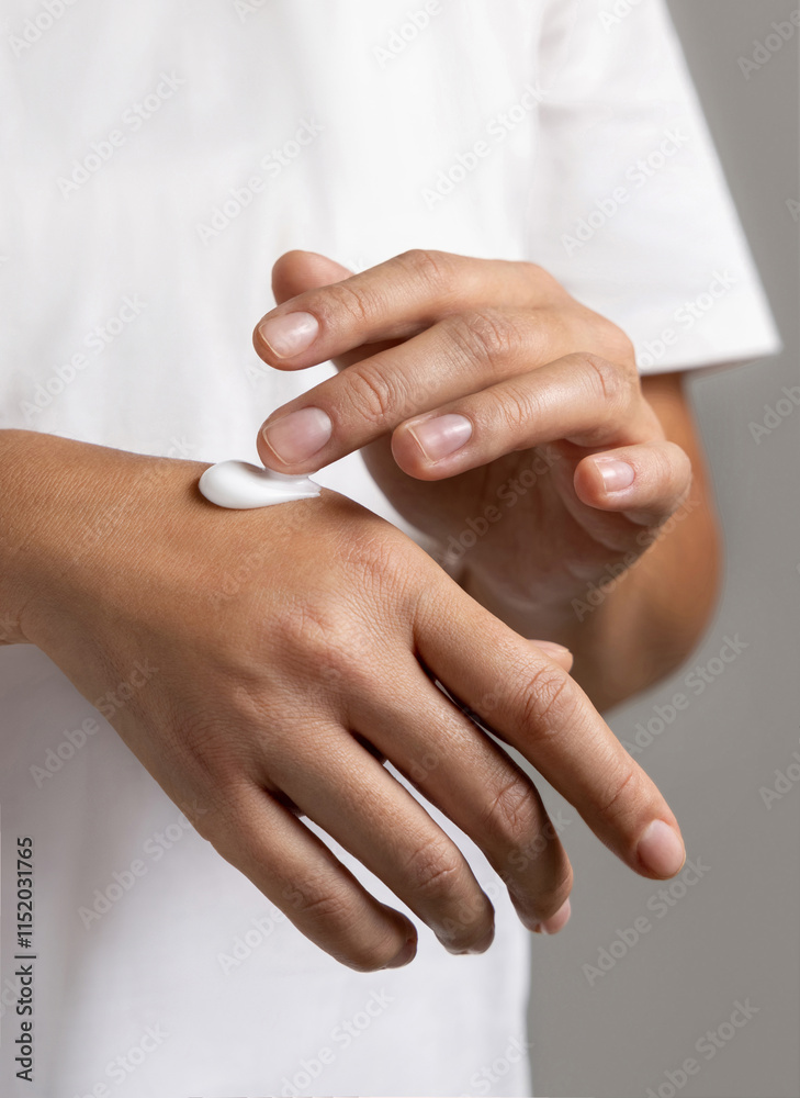 Woman in white t-shirt applying cream on hand to care and protect skin closeup Woman in white t-shirt applying cream on hand to care and protect skin closeup