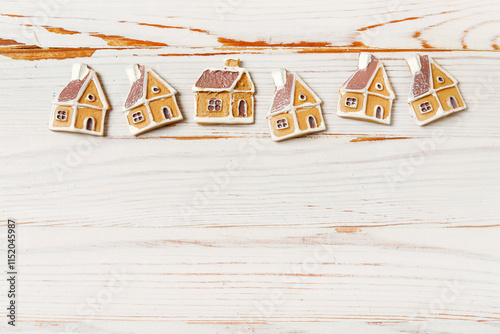 Obraz na płótnie Classic Christmas backgound with tiny gingerbread cookies in house shape on white wooden background. w salonie