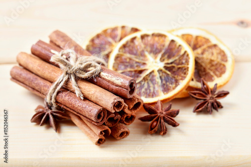 Obraz na płótnie Cinnamon sticks and dried oranges on wooden table. w salonie