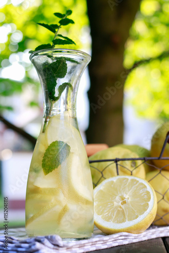 Obraz na płótnie Lemonade in the bottle and fresh fruits in wire basket. Summer garden party. w salonie