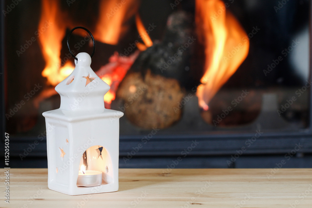 Ceramic lantern with candle inside. Fireplace in the background.