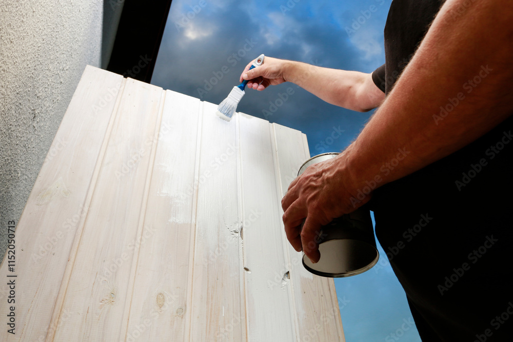 A person is painting a wooden door.