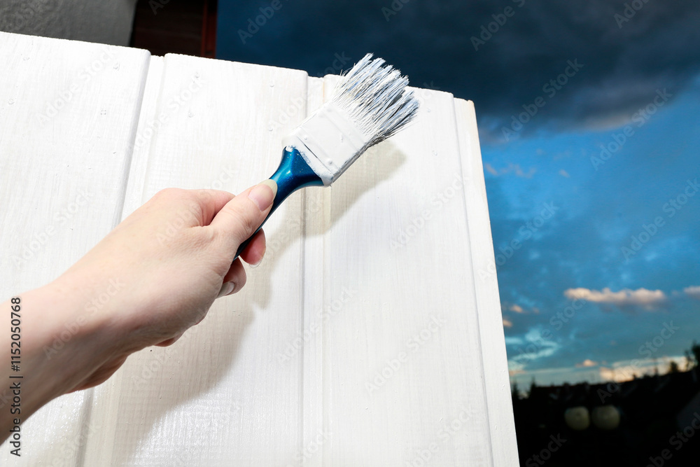 A person is painting a wooden door.