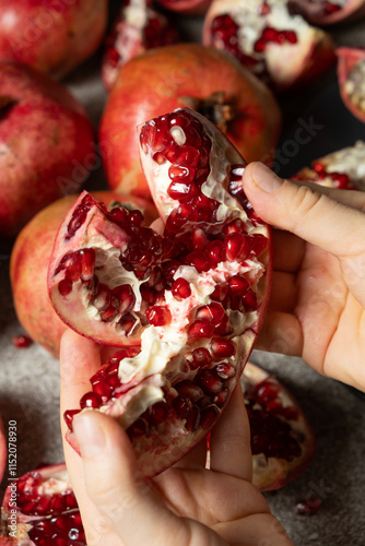 Hands open the pomegranate, separation into parts, pomegranates grains photo