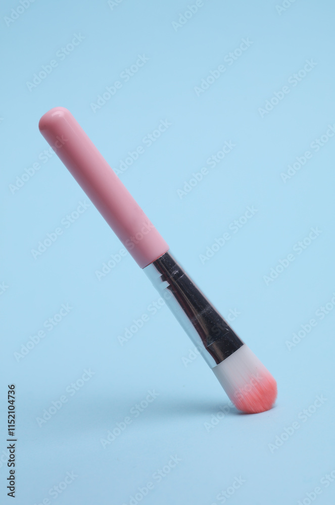 Pink makeup brush on blue background Pink makeup brush on blue background