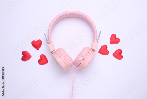 Wired stereo headphones with red hearts on white background. Top view