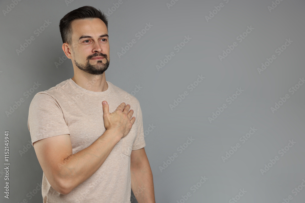 Man making promise on grey background, space for text. Oath gesture Man making promise on grey background, space for text. Oath gesture