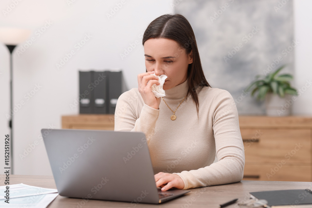 Sick woman with runny nose working at table in office Sick woman with runny nose working at table in office