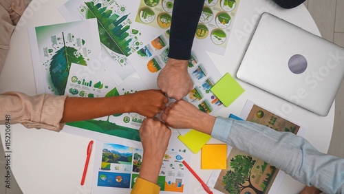 Φωτογραφία Top view creative project team meeting in boardroom at desk, discussing ecological project, presenting visual concept graphics, making team fist bump hand gesture