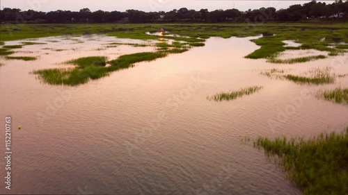 Flying over salt marsh and estuary in South Carolina at sunset with sky reflecting in the water. photo