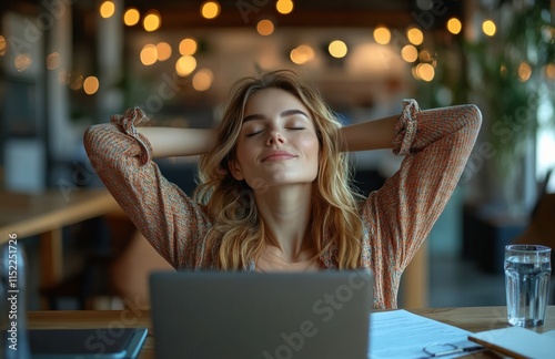 Relaxed young woman unwinding at her desk after work photo