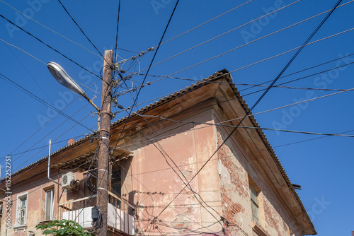 Lots of wires on the lamp post. Tangle of wires, electrical mess.