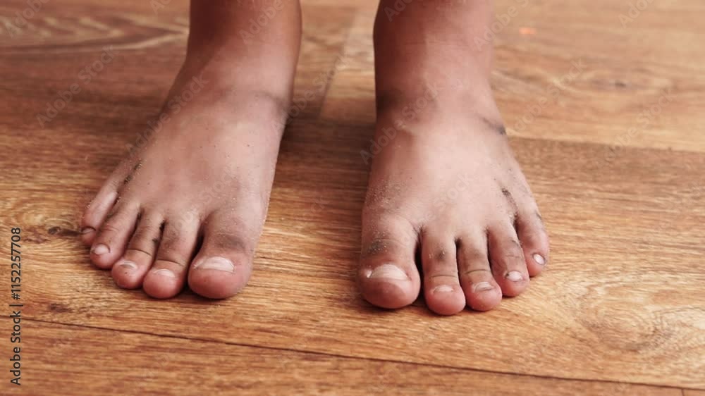 Close up of a child's bare dirty feet standing on the floor Close up of a child's bare dirty feet standing on the floor