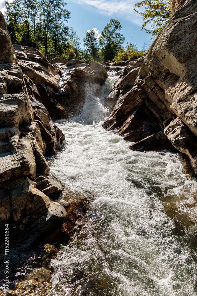 Fototapeta premium A waterfall is flowing down a rocky cliff