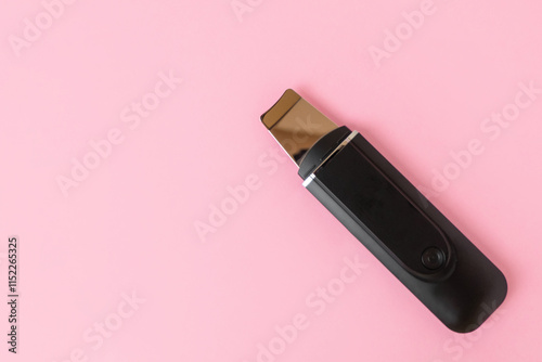 Ultrasonic skin scrubber on pink background
